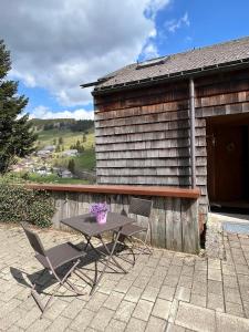 a table and chairs on a patio with a building at Ferienwohnung Black Forest Hideaway in Todtnau