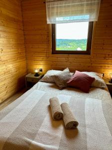 a bedroom with a bed with two towels on it at Siedlisko Wataha 721-140-600 in Wołkowyja