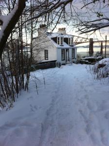 a white house with snow on the ground at Forth Reflections Self Catering in Queensferry