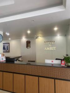 a hotel counter with a sign on the wall at Hotel The Amrit in Jabalpur