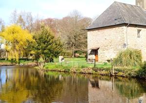 an old stone building next to a river at La Synchronicité - Chambres d'Hôtes in Vaudrimesnil