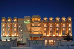 a large building with a sign on it at night at Lemon Tree Hotel, Sri Ganganagar in Gangānagar