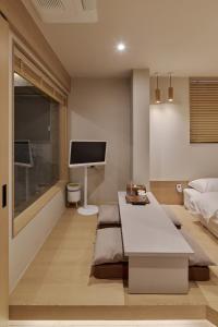 a living room with a bed and a tv at 웨일로 서울김포공항점 in Seoul