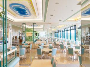 a restaurant with tables and chairs and windows at Shiretoko Daiichi Hotel in Shari