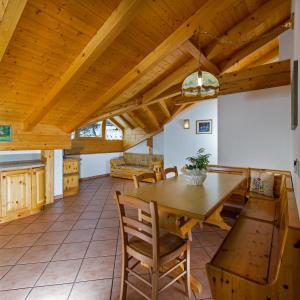 Residence Villa Boschetto في كارانو: مطبخ وغرفة طعام ذات سقف خشبي