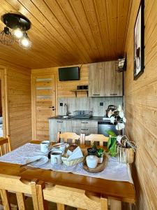 a wooden kitchen with a table with chairs and a tableablish at Siedlisko Wataha 721-140-600 in Wołkowyja
