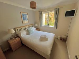 a bedroom with a large white bed with a window at Yarg Cottage in Falmouth +12 photos