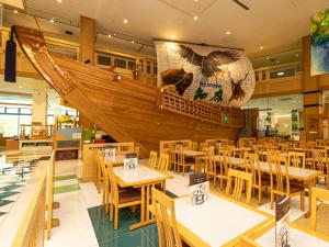 a restaurant with tables and a boat on the wall at Shiretoko Daiichi Hotel in Shari