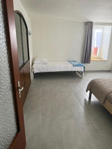 a room with two beds and a window and a door at Pâquier 3 in Saint-Sulpice