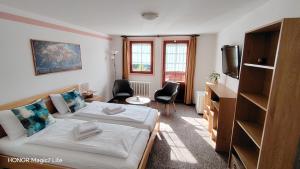 a living room with a bed and a tv at Rodinný "Hotel U Můstků" in Desná