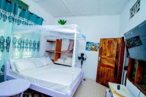 a bedroom with a white bed in a room at Avana Studio Watamu in Watamu