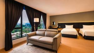 ein Hotelzimmer mit einem Bett, einer Couch und einem Fenster in der Unterkunft Bond Hotel Rawang in Rawang + 39 Fotos
