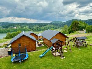 a house with a playground with a slide and swings at Siedlisko Wataha 721-140-600 in Wołkowyja