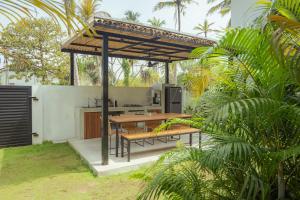 an outdoor kitchen with a wooden table and benches at Air Villa in Ahangama +12 photos