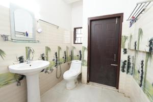 a bathroom with a toilet and a sink at Hotel Zimin Ziro in Ziro