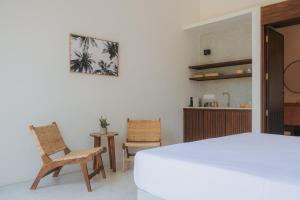 a bedroom with a large white bed and two chairs at Air Villa in Ahangama