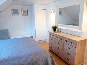 a bedroom with a bed and a dresser with a mirror at Heidis Loft in Vidstrup