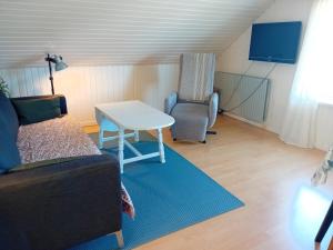 a living room with a couch and a table and a chair at Heidis Loft in Vidstrup