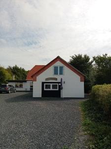 a white garage with a car parked in a driveway at Heidis Loft in Vidstrup