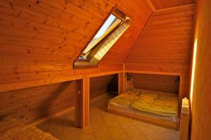 an attic room with a bed and a window at Bringatanya in Balatonkenese