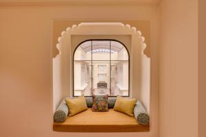 a couch sitting in a room with a window at Lemon Tree Hotel, Sri Ganganagar in Gangānagar