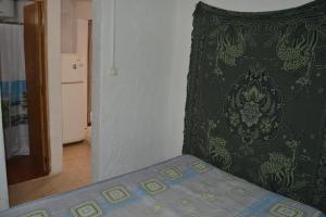 una cama en una habitación con una almohada verde en Apartamentos Flor de Lis, en La Paloma