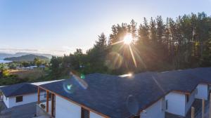 un techo de una casa con el sol en el fondo en Cabañas Lomas de Ensenada, en Licán Ray
