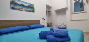 a bedroom with a blue bed with blue pillows at Il Vicoletto in Pisticci