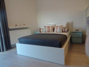 a bedroom with a large bed with a white headboard at Studio POZ in Poznań