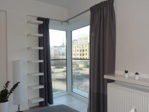 a living room with a large glass door with a window at Studio POZ in Poznań