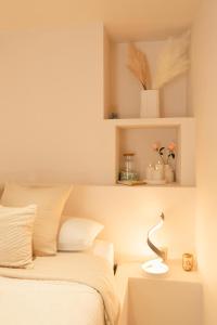 a bedroom with a bed and a table with a lamp at Suite Pacifique - Spa privatif avec baignoire in Calais