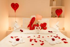 a bed with red hearts and roses and balloons at Suite Pacifique - Spa privatif avec baignoire in Calais