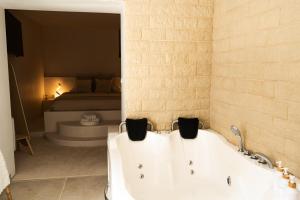 a bath tub in a room with a bed at Suite Pacifique - Spa privatif avec baignoire in Calais
