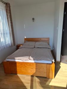 a bedroom with a wooden bed in a room at Pensjonat nad Stawem in Sarbinowo