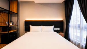 ein Schlafzimmer mit einem Bett und einem großen Fenster in der Unterkunft Bond Hotel Rawang in Rawang