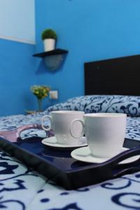 dos tazas de café en una bandeja en una cama en Aracoeli, en Roma