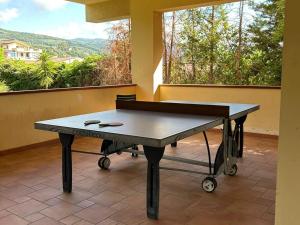 a ping pong table in front of a window at Magico Apartments - 450m dalla spiaggia in Capo dʼOrlando