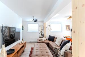 a living room with a couch and a table at Pretty Little House in Saguenay