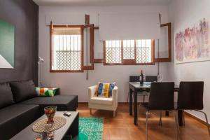 een woonkamer met een bank en een tafel bij My Little Loft in the Heart of Seville in Sevilla