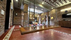 a large room with a wooden table in a brick wall at Mutram Heritage Stay in Kanchipuram