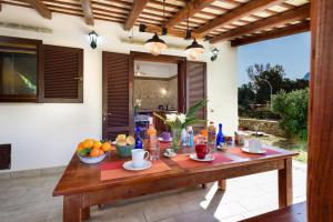 a wooden table with fruit and drinks on a patio at SanVitoTour- Residence Il Baglio in San Vito lo Capo