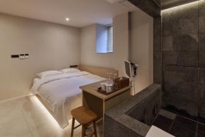 a bedroom with a bed and a television and a shower at 웨일로 서울김포공항점 in Seoul