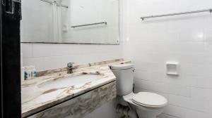 a bathroom with a sink and a toilet and a mirror at Seaboard Apart Hotel in Durban