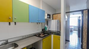 a kitchen with yellow and blue cabinets and a sink at Seaboard Apart Hotel in Durban +19 photos