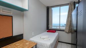 a small room with a bed and a window at Seaboard Apart Hotel in Durban