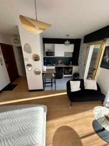 a living room with a couch and a kitchen at Charmant Studio in Vitré