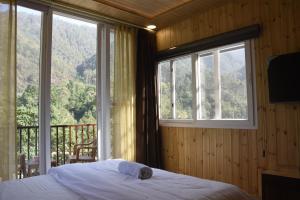 a bedroom with a bed in front of a window at Hotel Dev Darshan in Uttarkāshi +27 photos