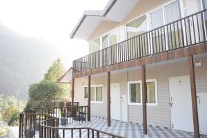 a house with a balcony with a white door at Hotel Dev Darshan in Uttarkāshi