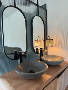 a bathroom with two sinks and two mirrors on a counter at uBa Vineyard Stay con vistas al Miño Ribeira Sacra in Chantada +25 photos