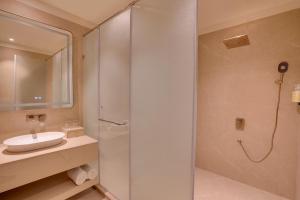 a bathroom with a shower and a sink at Lemon Tree Hotel, Sri Ganganagar in Gangānagar +38 photos
